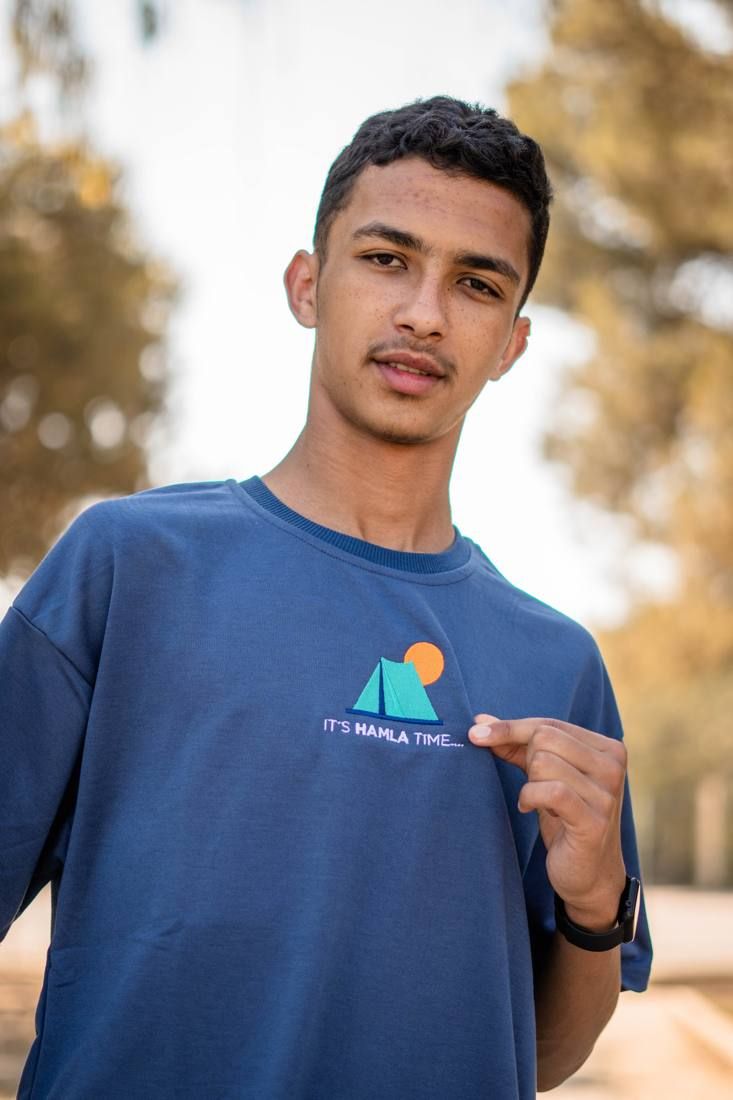 Young man in a blue branded t-shirt, photographed outdoors
