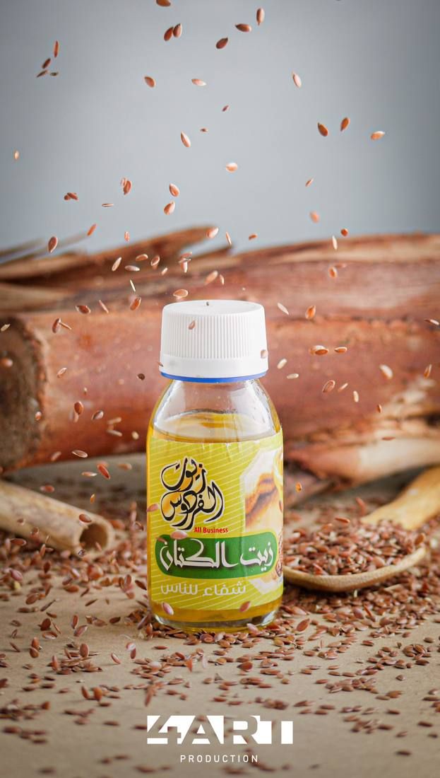 Bottle of flaxseed oil with seeds falling around it